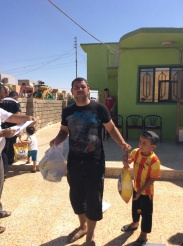 A Dad and his boy receive food and supplies for the family.